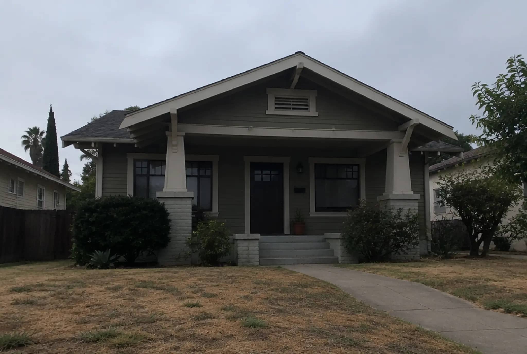 Example exterior before editing: flat gray sky and a dry, brown lawn